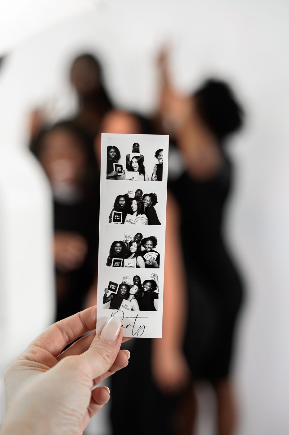 A guest holding a printed four-frame photo strip